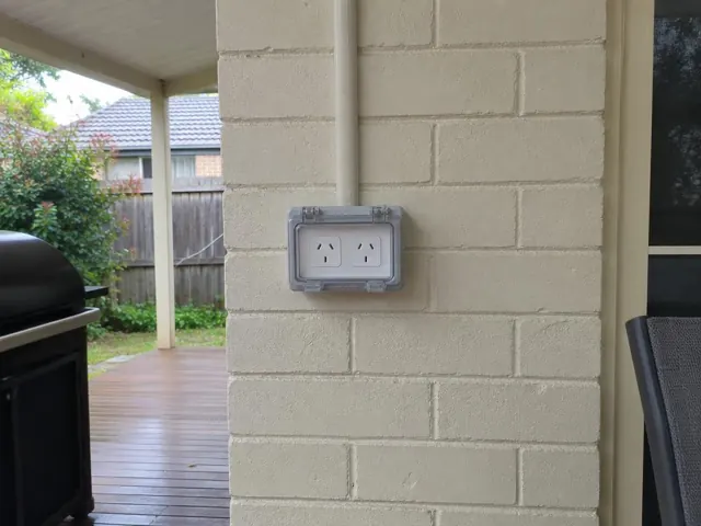 Outdoor double power point on a painted brick wall under a patio in Booragul